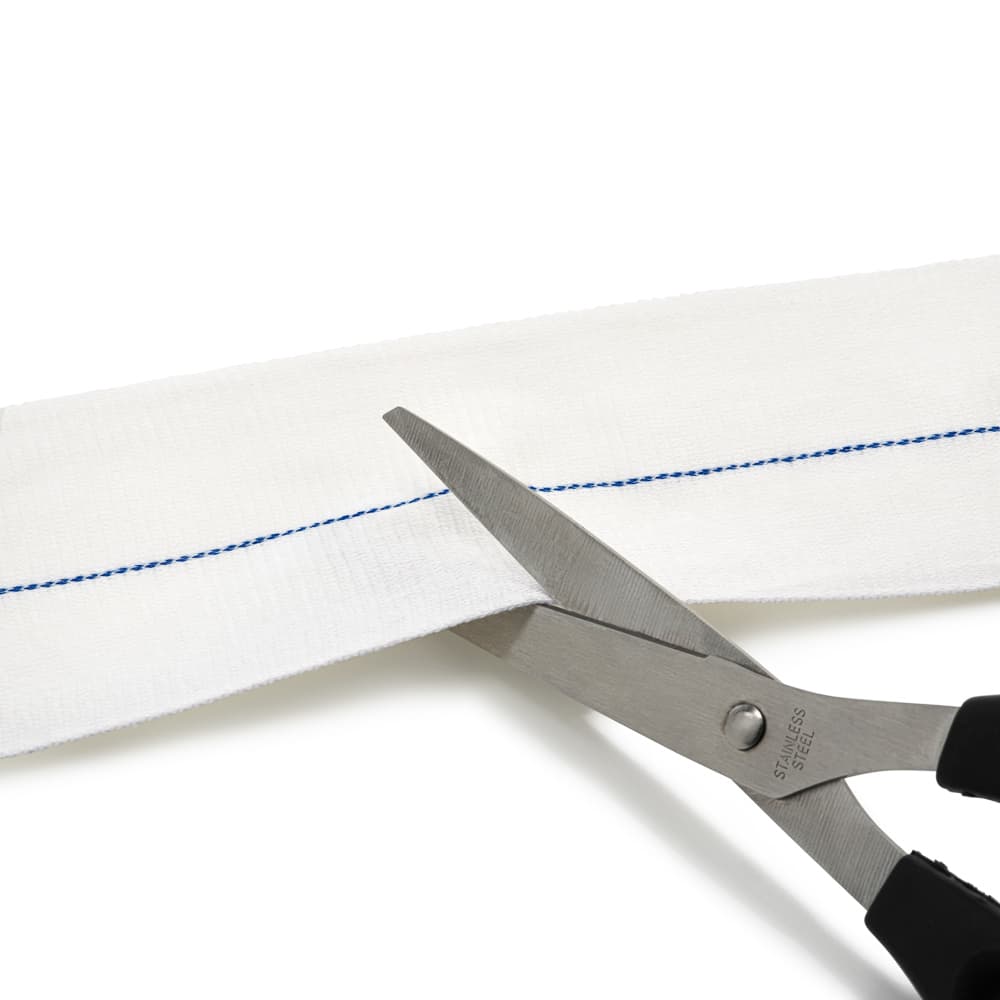 Scissors cutting a strip of light material