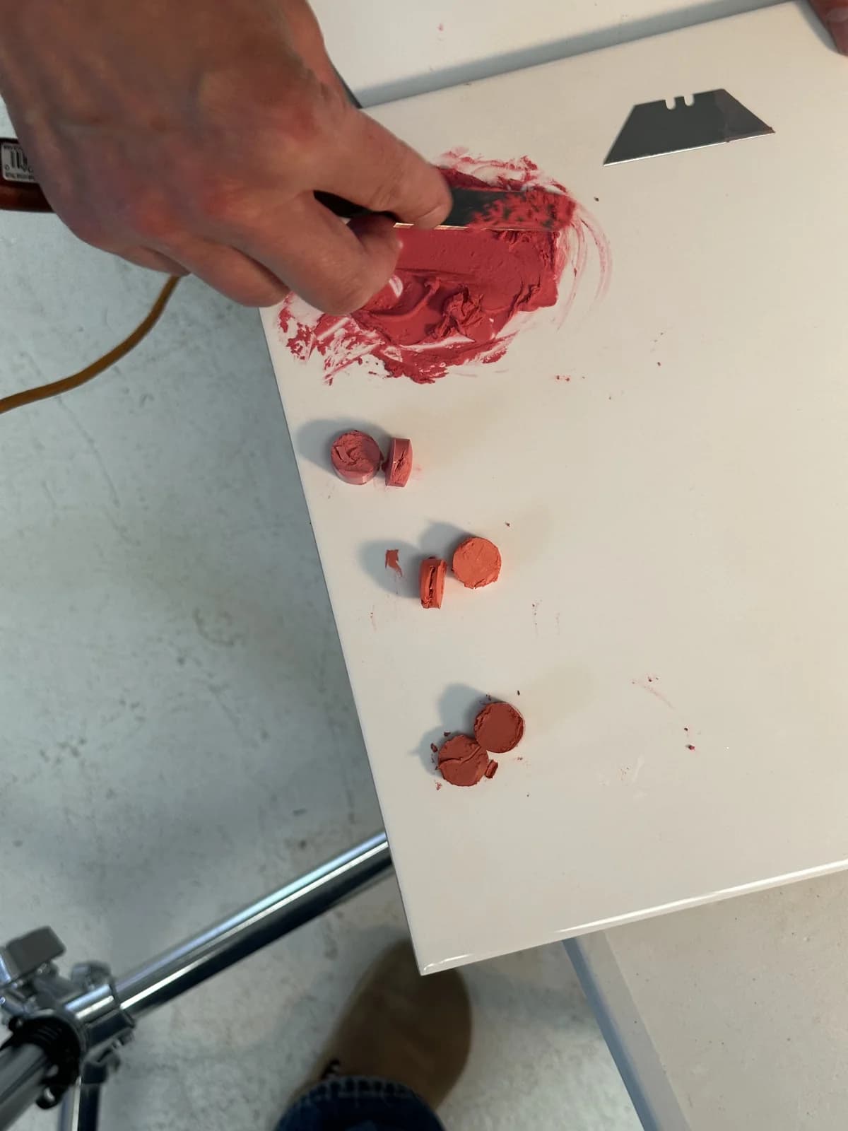 Shaping pink lipstick into a textured swatch by hand for the Doll Smash shoot