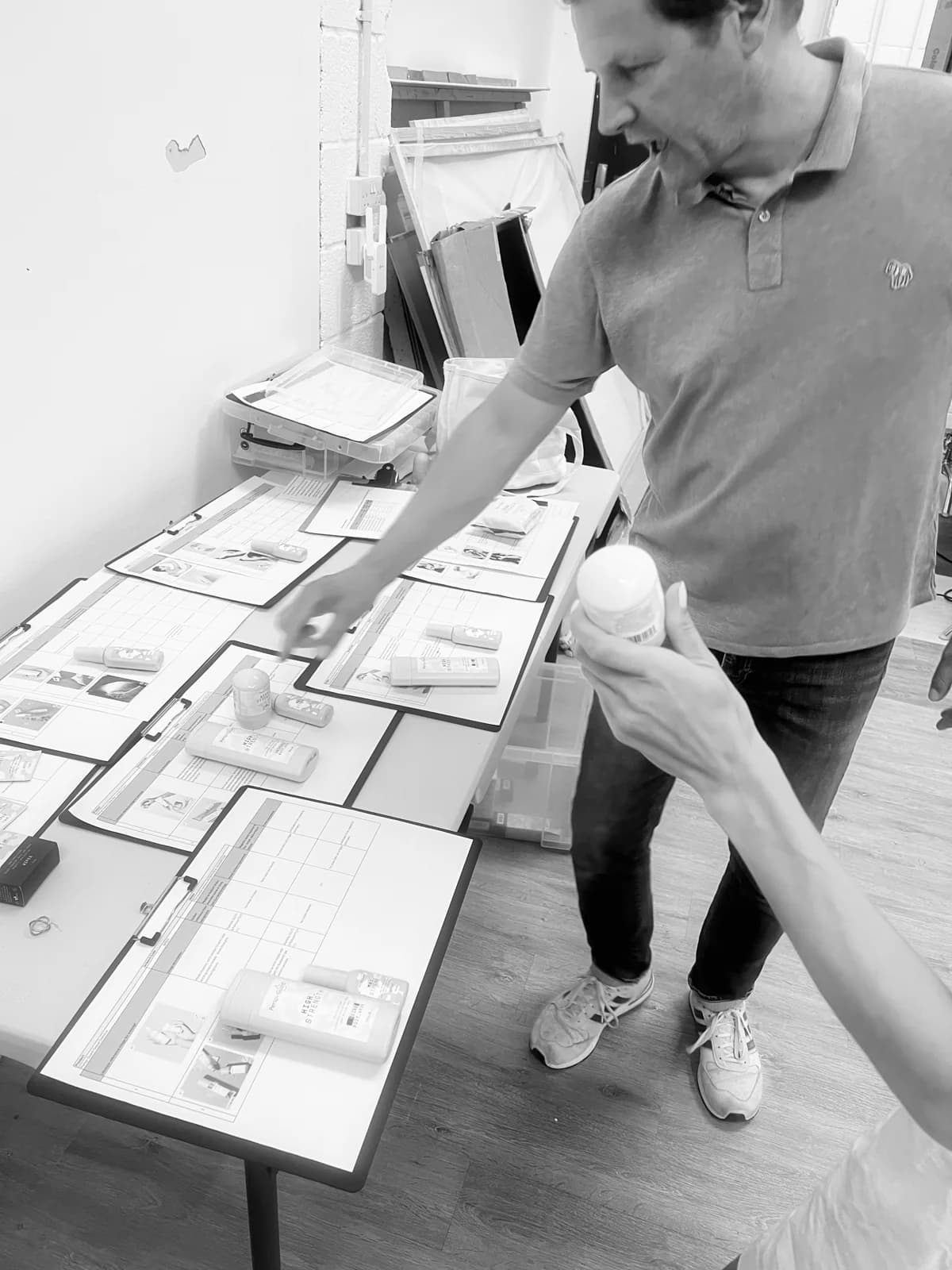 Reviewing printed photographic references beside the products before a studio shoot