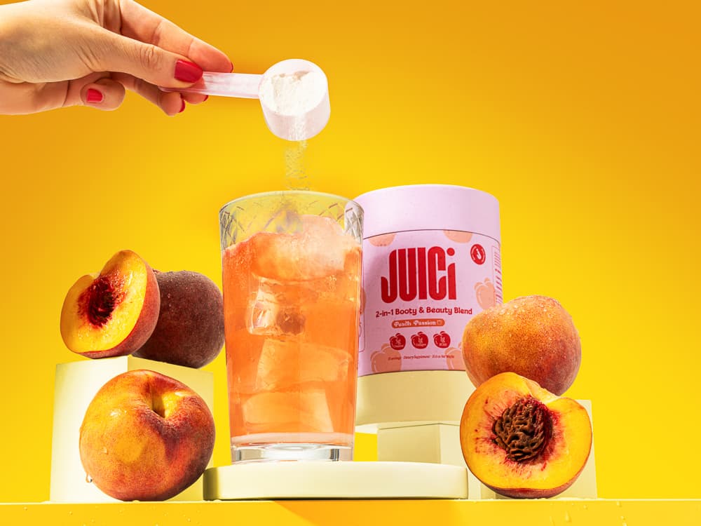 JUICI peach and passion fruit drink styled with fruit and a glass for a colourful lifestyle photograph