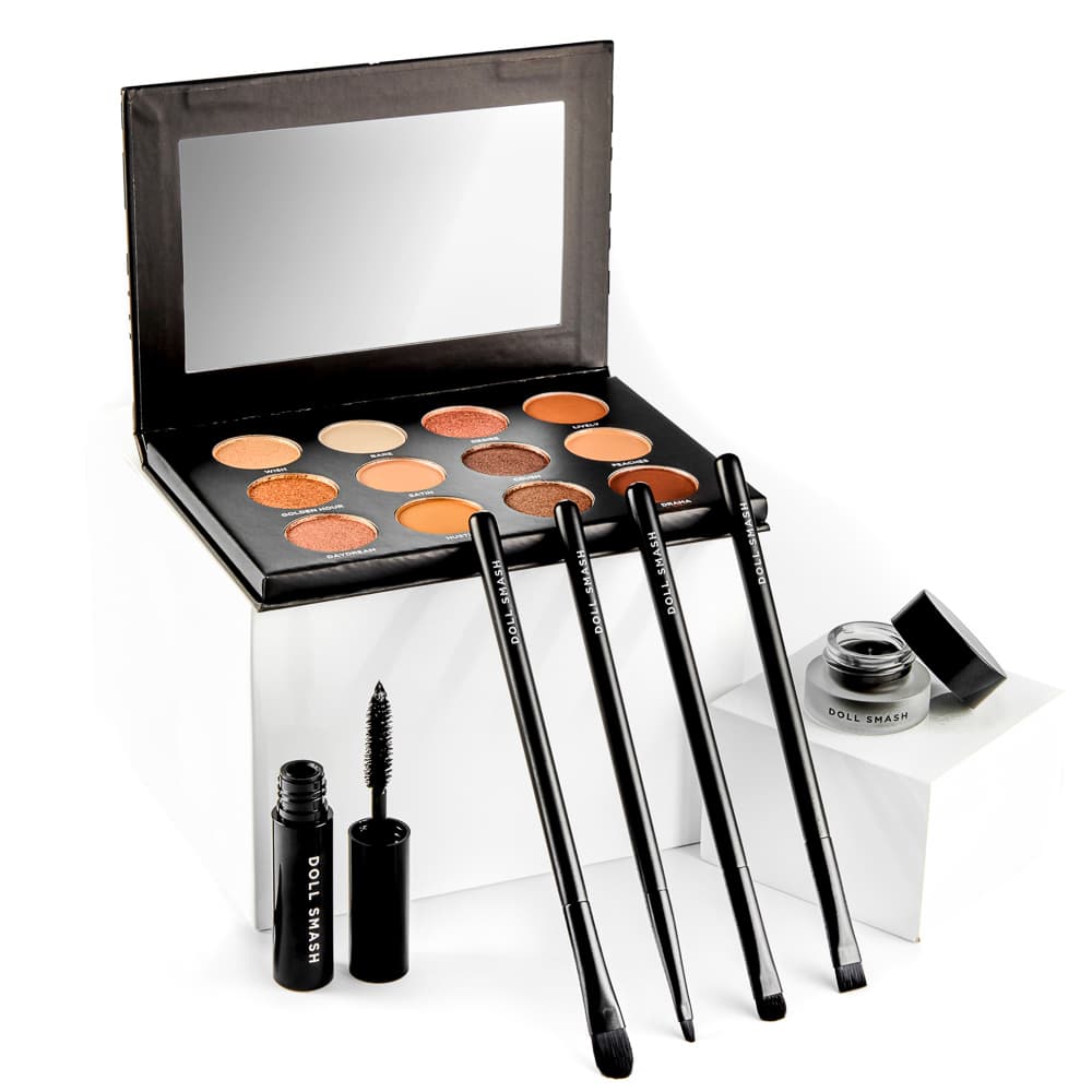Makeup palette and brushes arranged against white