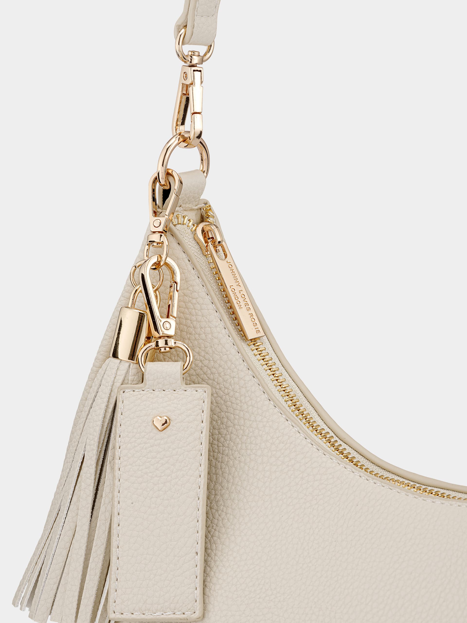 Close view of a cream bag handle and gold-tone fastening