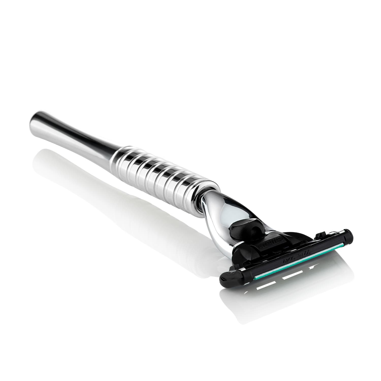 Metal safety razor photographed against white