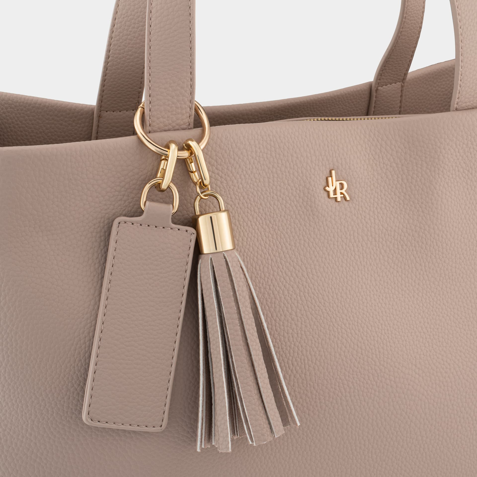 Taupe bag with its handle hardware and tag visible