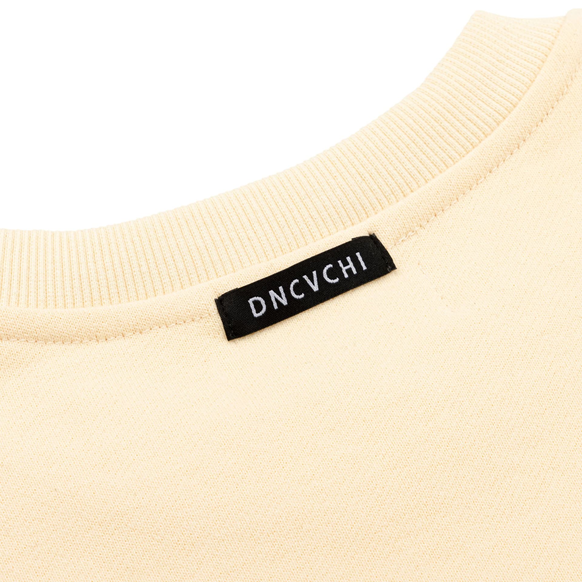 Close-up of a cream sweatshirt showing the neckline, stitching and DNCVCHI label