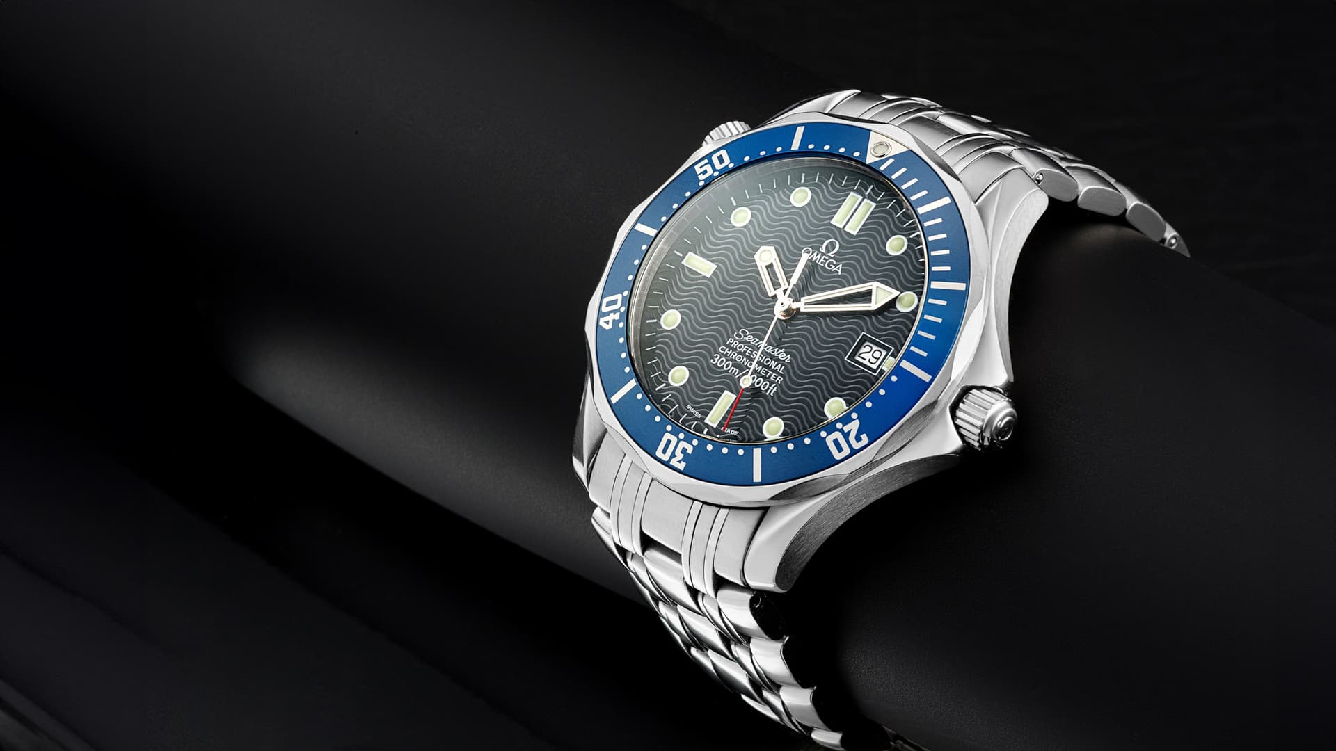 Blue-faced metal watch against a dark background
